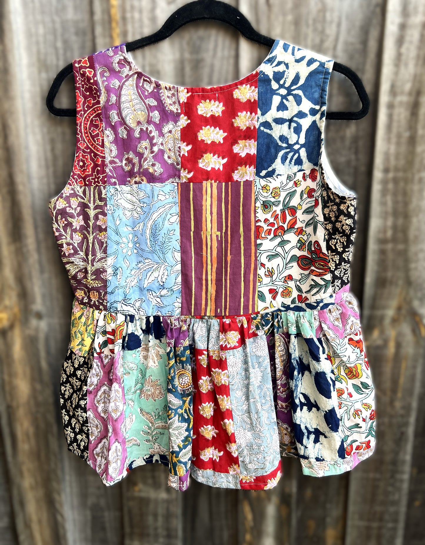 Back of a Colorful hand block patchwork top on a wooden background