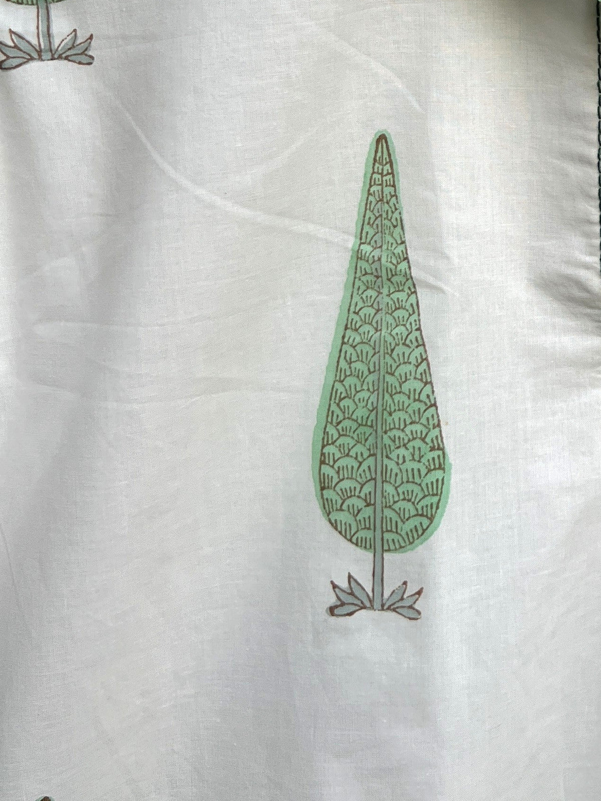 A close up of the cypress saanjh kurta motif with green leaf patterns.