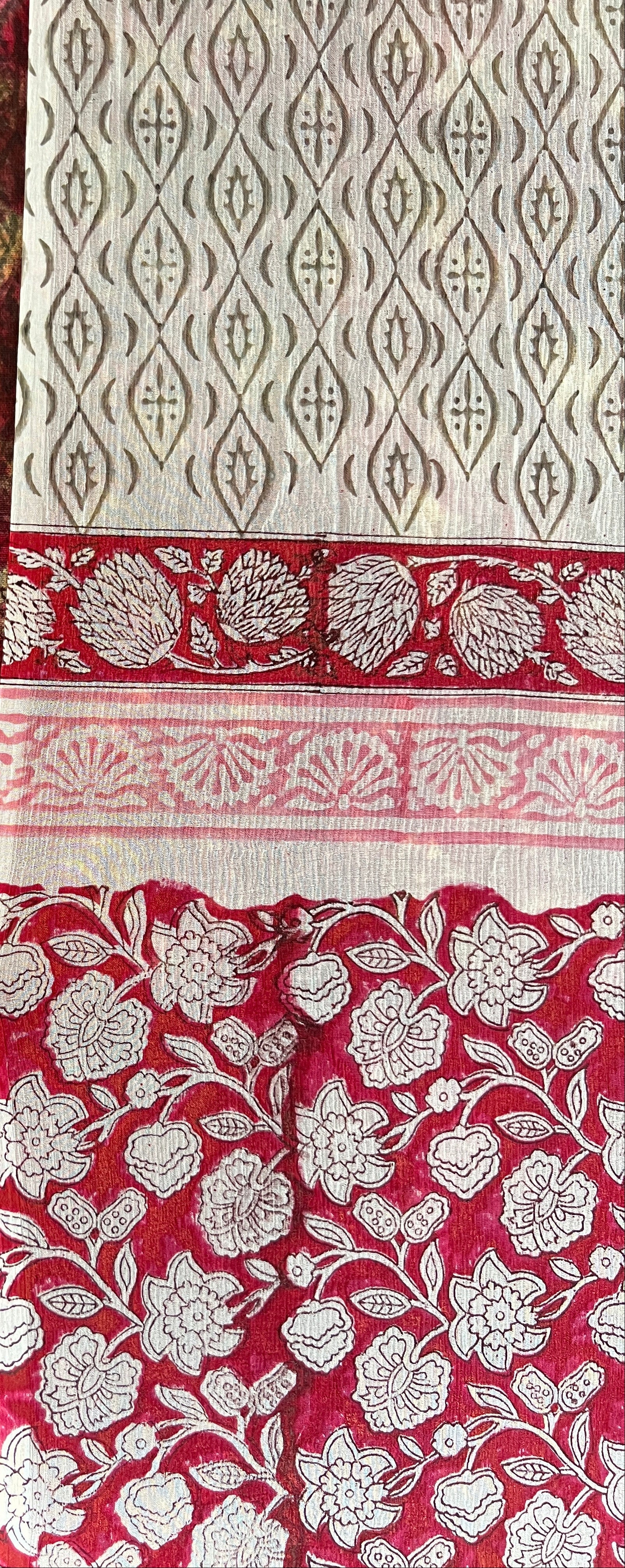 Close-up of red and white patterned fabric with a textured brown background