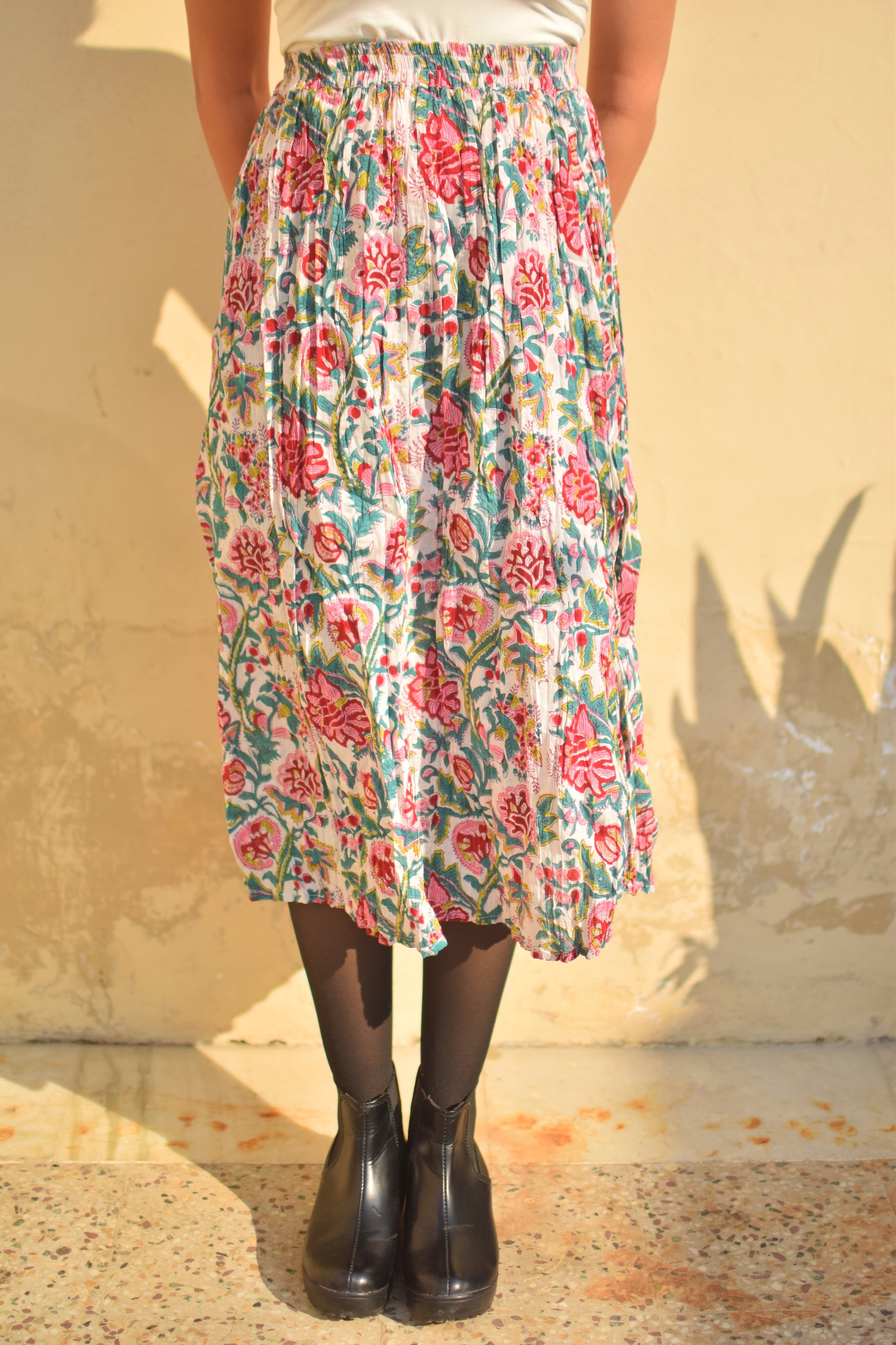 Person wearing a floral skirt with a plain background