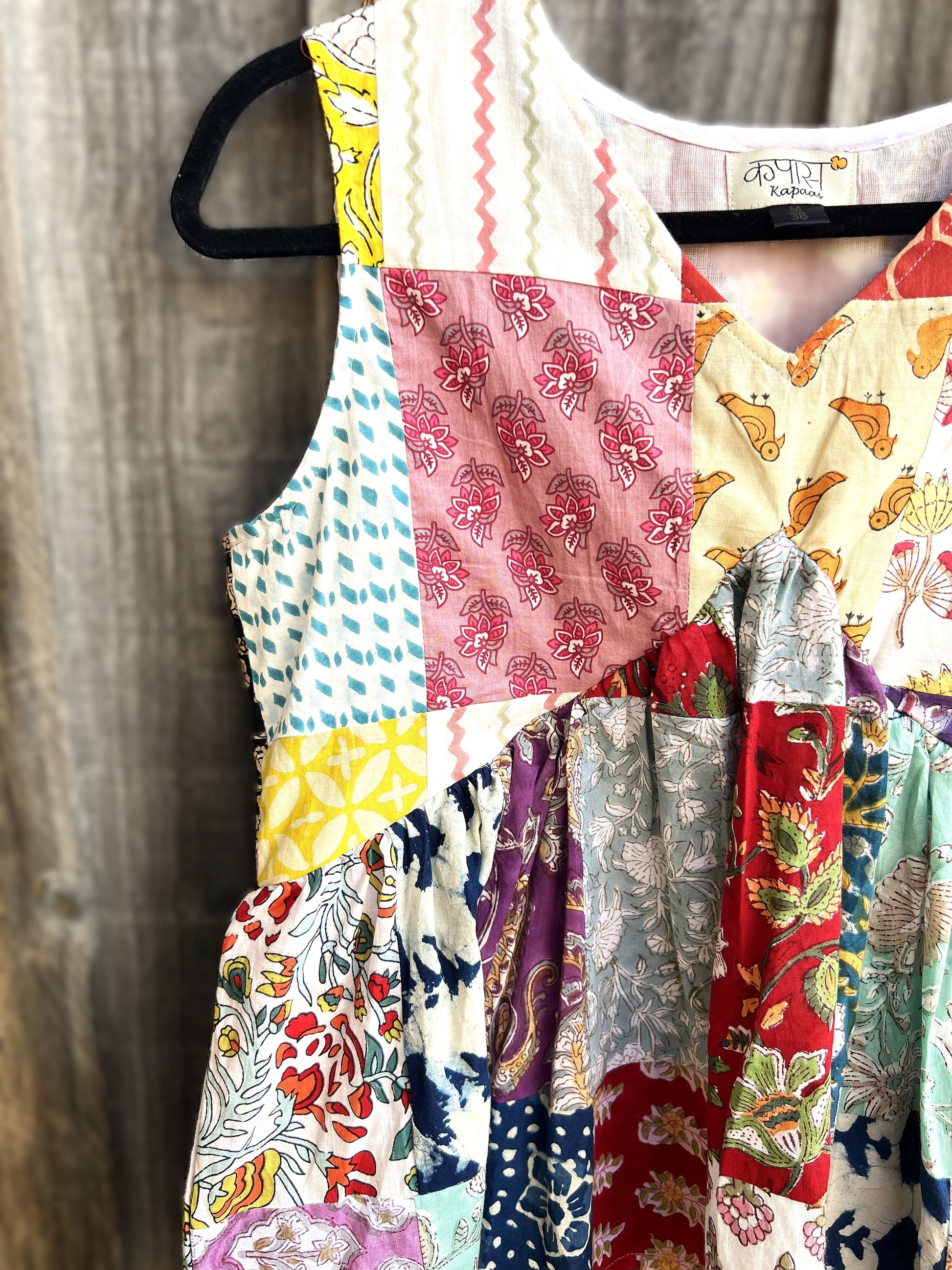 Colorful patchwork hand block top on a wooden surface