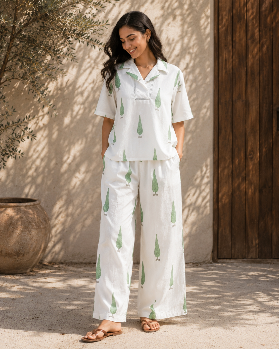 Woman wearing white sage cypress print co-ord set standing outdoors.